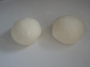 step3: 取出麵糰排氣，分做2份滾圓，蓋上濕布放置醒麵10分鐘。 用麵棍將麵糰搌平成焗盤的大小，焗盤塗上少許油，放上薄餅，用叉子在薄餅中央尖上小洞，留少許邊緣。用保鮮紙包好，放入雪櫃備用。