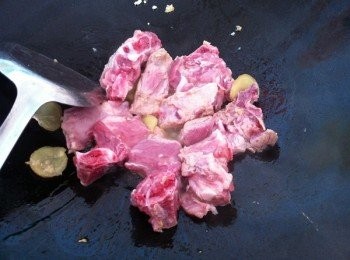 step2: 取出鍋下1小匙食油爆香蒜蓉，薑片和豆瓣醬。再下排骨炒干水分。