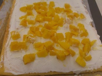 step9: 將忌廉加糖和雲妮拿油打發到企身即可,再將忌廉塗上蛋卷內卷,(需預留部分忌廉塗蛋糕表面),之後再加上芒果粒。