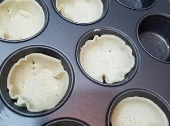 step2: 將酥皮切圓形，放入已鬆油嘅鬆餅杯入面。 用卡喺酥皮上面拮細孔， 再塗上蛋漿。