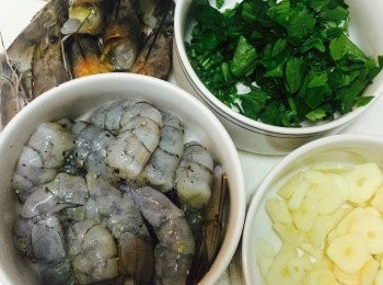 step1: 海蝦洗淨，去頭去殼去腸留尾，加鹽和黑椒拌勻備用。蝦頭留下，香芹葉切碎，蒜頭切片。