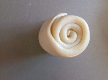 step12: 把小面筒子直立起来（卷圈面朝上）用手指把接口处按着， 再用手掌将面筒往下倾向接口处压，把接口处压在圆饼下