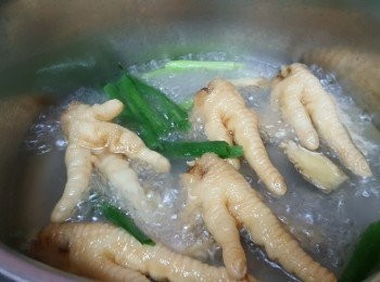step2: 炸鳳爪可在冷凍食品店買到，將炸鳳爪剪去尖爪，放入鍋中，加入蔥段和薑片、倒入清水煮滾再出水3分鐘，撈出洗淨瀝乾水份備用