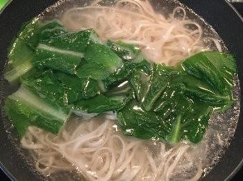 step7: 煮沸ㄧ鍋水，放入麵條，煮熟到自己喜愛的軟硬度即可，順便將青菜也ㄧ起燙熟，青菜燙好後先撈起備用。麵條煮好後撈起，瀝去多餘水份，接著將麵條排入湯碗中，放上燙好的青菜，將蔬菜高湯用濾網濾入碗中，並擺上切好的排骨，加上少許紅蔥酥，撒上蔥花。喜歡的話也可以再加上對切的溏心蛋。