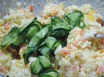 step5: 小黃瓜片手捏壓去苦水，加入沙拉中，然後撒上一點點鹽後拌勻