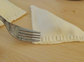 step4: 用少許水封口，對摺，再用叉緣邊位壓紋。在酥皮上塗一層蛋液