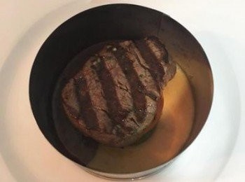 step7: 先放上一片青椒圈，再放一片蕃茄片，接著放上牛里肌；再加一圈青椒圈；再ㄧ層蕃茄片，最後放上蛋，並將蒜頭放在蛋黃上，便可移開模具。