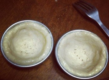 step2: 模型杯內部塗上橄欖油(或沙拉油)，以防沾黏，將<span class="group_1">派皮</span>放入模型杯，整形，然後在底部戳洞