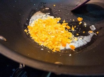 step6: 整個鹹蛋嘞。牛油同蛋黃好易黑，要中細火。先落牛油，大概一湯羹咁上下啩。緊住一茶蒜茸爆一爆，再落埋啲蛋黃慢慢撈埋。
＊如果發覺太乾身，要再落多少少牛油。