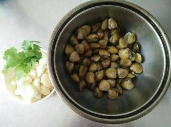 step1: 黃金蜆先加入塩巴，並以冷水吐沙約3-5小時，約1-2小時，需換水清洗再重泡吐沙至清水洗淨時吐沙時，水無泥沙、雜質即可；敲蒜頭並去頭尾，剝掉外膜，對切小成小塊；鍋中放入2000cc的水；香菜1小片；備用；