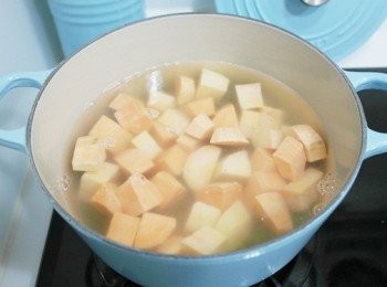 step3: 當綠豆有點變色沒那麼綠時加入適當的熱水與地瓜塊，中火煮至滾。