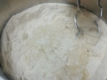step1: 在一大碗內，將麵粉，乾酵母，鹽拌勻，再下橄欖油及300毫升的水，用打蛋器的打麵糰鉤開始打發，先用慢速打發兩分鐘