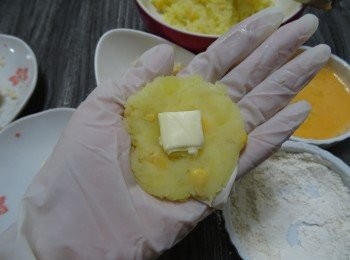 step4: 用匙羹盛適量薯蓉在手中壓平,  包入芝士粒， 裹成球狀