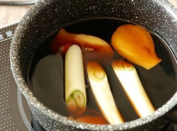 step4: 把日本豉油、日式料理酒、味醂、水、鰹魚素、薑和大蔥加入鍋中拌勻以中火煮滾後蓋上，調到小火煮10分鐘。