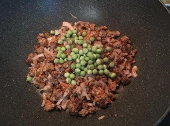 step2: 炒鍋放少許油，先將絞肉炒香，再下紅蔥頭片、紅蘿蔔丁、青豆仁拌炒。