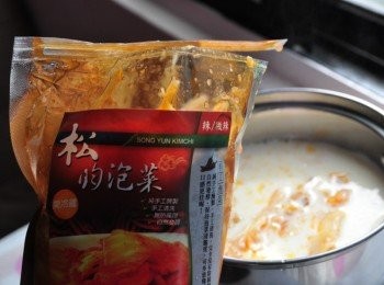 step3: 將豆漿煮滾後，轉中小火，放入適量的泡菜及湯汁