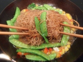 step13: 用筷子拌炒(用雙手拿筷子將米粉挑起拌鬆的動作)。利用筷子來拌炒可讓米粉吸收了湯汁裡的美味精華,且不會將米粉弄斷,口感更好吃。