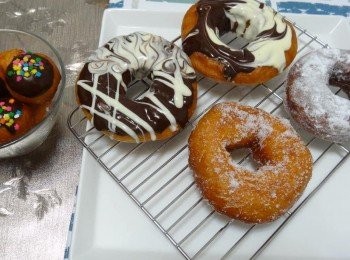 step6: 裝飾的部分： 1.盤子放適量糖粉，沾糖粉 2.盤子放適量細砂糖，沾細砂糖 3.熔化雙色的巧克力，沾巧克力做造型 （沾糖粉或細砂糖的部分，建議剛炸完的甜甜圈稍微瀝油後，還有點溫度時，就去沾糖，以免糖無法附著；巧克力的部分，待甜甜圈為常溫時，再裝飾即可）