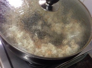 step1: 將爆谷米平鋪在平底鍋上那入巳溶的牛油溶液緊緊沾住每一粒爆谷米便可以了，蓋上鍋蓋開中小火慢慢烤至爆谷劈劈啪啪彈起爆開