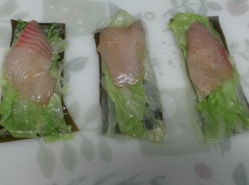 step7: 在昆布上依序鋪上同樣大小的2層高麗菜葉、醃好的鯛魚片(鯛魚片的長度約昆布的2/3長)。
