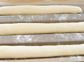 step7: 不停將麵糰前後推，令麵糰拉長至理想長度，將麵糰放在法包焗盤上 （*如沒有，可放在鋪有烘焙紙的焗爐盤上），蓋上布，靜置30分鐘