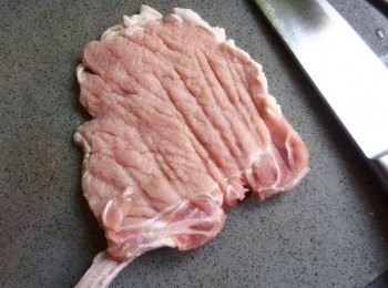 step2: 將豬排放在保鮮袋裡,用桿麵棍敲打至鬆軟狀,或用刀背直接拍打豬排亦可。