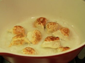 step2: 平底鍋加少許油小火加熱，將玉米雞肉水餃排入鍋中小火煎3~5分鐘待水餃上色，倒入麵粉水蓋上鍋蓋以中小火加熱至5~6分鐘，當水餃呈透明狀打開鍋蓋繼續小火燒至水份收乾，將水餃取出放入盤中。