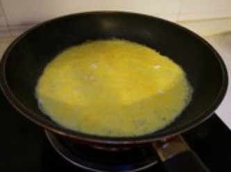 step5: 微熱平底鍋，在鍋底刷少量食用油以免蛋液粘鍋。將火力控制在小火，倒入蛋液，拿起搖勻，攤成餅狀；