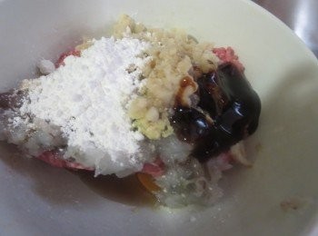 step2: 肉馅，冬菇末，虾泥放在一起，打1个鸡蛋，和一大勺淀粉，搅匀，顺时针搅打上劲。
加入盐，糖，胡椒粉，料酒，蚝油和薑泥调味，和烧卖馅拌匀。