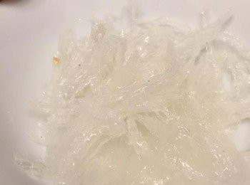 step4: 做慕絲部分，大菜絲用水浸軟；渣乾水份。熱鍋慢火煲滾水，加入大菜絲不停攪拌煮熔，再加入椰奶，不停攪拌，確保大菜絲完全溶解。熄火，加入龍舌蘭蜜拌勻。