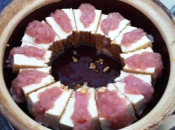 step2: 取出砂鍋1匙食油爆香蒜蓉，把釀好的豆腐排好。