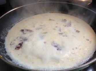 step3: 在鍋裡倒油放入蒜粒，讓油爆香，放入培根，煎一會，接著倒入鮮奶油