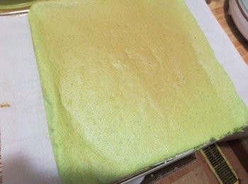 step6: 烤温180度 中下层上下火 烤18分钟左右后取出移到冷却架上，根据自己的烤箱温度，如果正卷，就要加开循环风功能再多烤三分钟，加固外皮，以防止卷的时候掉皮。 底皮焦黄，解决办法：要么减少时间，要么降低温度。 皮不够干，有余湿，解决办法：延长时间或提高温度 总之根据情况找规律，每家烤箱不同品牌，不同脾气，总结一下更有助于进步。烘焙时间到了以后，取出烤盘，用力震出热气，用手提油布边缘，将蛋糕连同油布一起脱离烤盘，掀开四周垫上晾网散出热气。