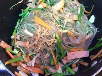 step4: 原鑊加些許油爆香蒜片。下韮菜花，爆香；下雲耳絲、甘筍絲，炒勻；加鴻喜菇，炒至開始軟身。拌入午餐肉同粉絲，炒至全部熱透。