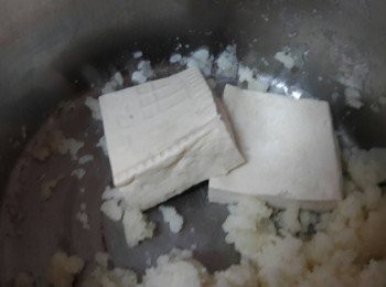 step2: 豆腐對剖後用重物壓著 , 十五分鐘後把水倒掉 , 再用叉子把豆腐壓碎