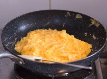 step3: 開中火，鍋中下油，油熱後轉到中慢火，倒入拌好之蛋漿，每看到底部結成薄薄一層蛋皮就推向中間（可用剷子或筷子），直到蛋漿不再流身如水狀，整個炒蛋大約五成熟左右（如圖）即可關火取起備用
（千萬不要不停撥散雞蛋，完成這個步驟之後應該為一大塊炒蛋）
