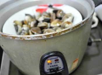 step1: 先將吐沙過後的蛤蜊，放入盤中再置入電鍋蒸煮，外鍋1量杯水
