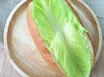 step5: 將熱狗麵包攤開放入蘿美生菜再加入蒟蒻小寬麵擠上美乃滋及柴魚片後即可享用。