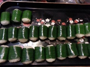 step16: 拿一小飯團，壓平，加1湯匙鷄絲在飯中央，然後用手搓成飯團狀，再加一塊蕉葉沿飯團外包圍。