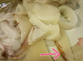 step1: 魷魚洗淨去皮，切一圈圈。（圖中箭咀的部位要好好認清楚，是很爽脆的呀,一隻只有兩片）