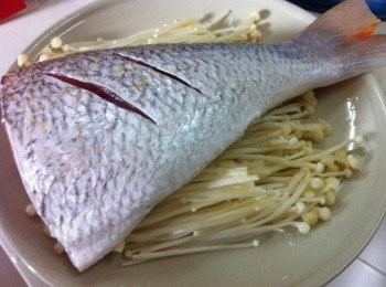 step2: 把魚尾洗淨，金針菇放在碟子上，魚尾在上，下鍋蒸熟