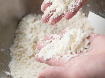 step3: 將低筋麵粉過篩進另一個缽盆，再加入奶油，用刮刀以切拌方式使奶油融入麵粉。一邊用手揉碎奶油，一邊搓揉、混拌奶油與低筋麵粉，使其變成如麵包粉的樣子。