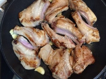 step3: 電飯鍋先倒入鎮江汁，按煮飯掣稍煮熱。點解唔直接倒埋入鑊到煮熱？因為我唔想要爆完骨嘅油囉！
另一邊用鑊下油爆香蒜頭，放豬仔骨煎至兩面金黃，鑊邊灒酒，不要油份，只夾起豬仔骨及蒜頭入電飯鍋，續炆30分鐘，其間反轉一至兩次使之色澤均勻。
不用電飯鍋用普通鑊亦可，將汁倒入煮滾收小火炆30分鐘即可。