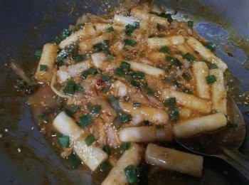 step2: 先熱鍋， 倒入橄欖油， 接著放入洋蔥炒香， 約略1分鐘，等香氣出來，開中小火，依序放入甜不辣小炒、加入澎湖年糕、少許泡菜、泰式甜辣醬、糖，並炒勻；
