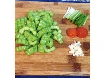 step1: 苦瓜對切後用湯匙把籽去除，也要把白色的皮都儘量刮乾淨後沖洗，這樣苦瓜就不會太苦了～苦瓜切小塊，蒜頭切末。