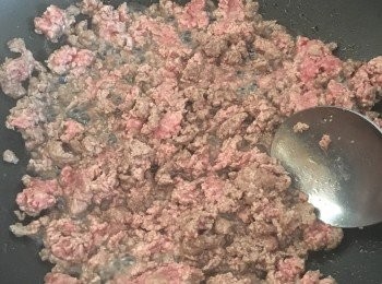 step4: 再倒入少許油，下牛肉末翻炒至八分熟，接著倒入番茄泥，翻炒一小會，再倒入番茄醬，適量紅酒或者清水，還有干香草。