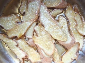 step3: 準備一個鍋放入適量的芝麻香油及薑片,用小火慢慢煸出香氣,煸至薑片邊緣捲起狀。