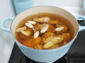step3: 將雞肉、薑片放入鍋中倒入適量的水，並且將料理鮑魚內的湯汁倒入(鮑魚還不用入鍋唷!!!)蓋上鍋蓋中小火悶煮約半小時。