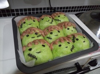 step3: 取出麵糰，排氣及翻麵，靜置10分鐘。兩份麵糰各分割成9份，滾圓，綠茶麵糰包入朱古力粒，收口向下，可可麵糰造成頭髮形狀放上綠茶麵糰，然後將綠茶麵糰放烤盤上發酵至兩倍大。