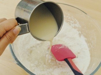 step6: 待粉團稍涼一分鐘，戴上膠手套，拿出一小份粉團，放紅豆蓉在中間，包好餡料，搓圓